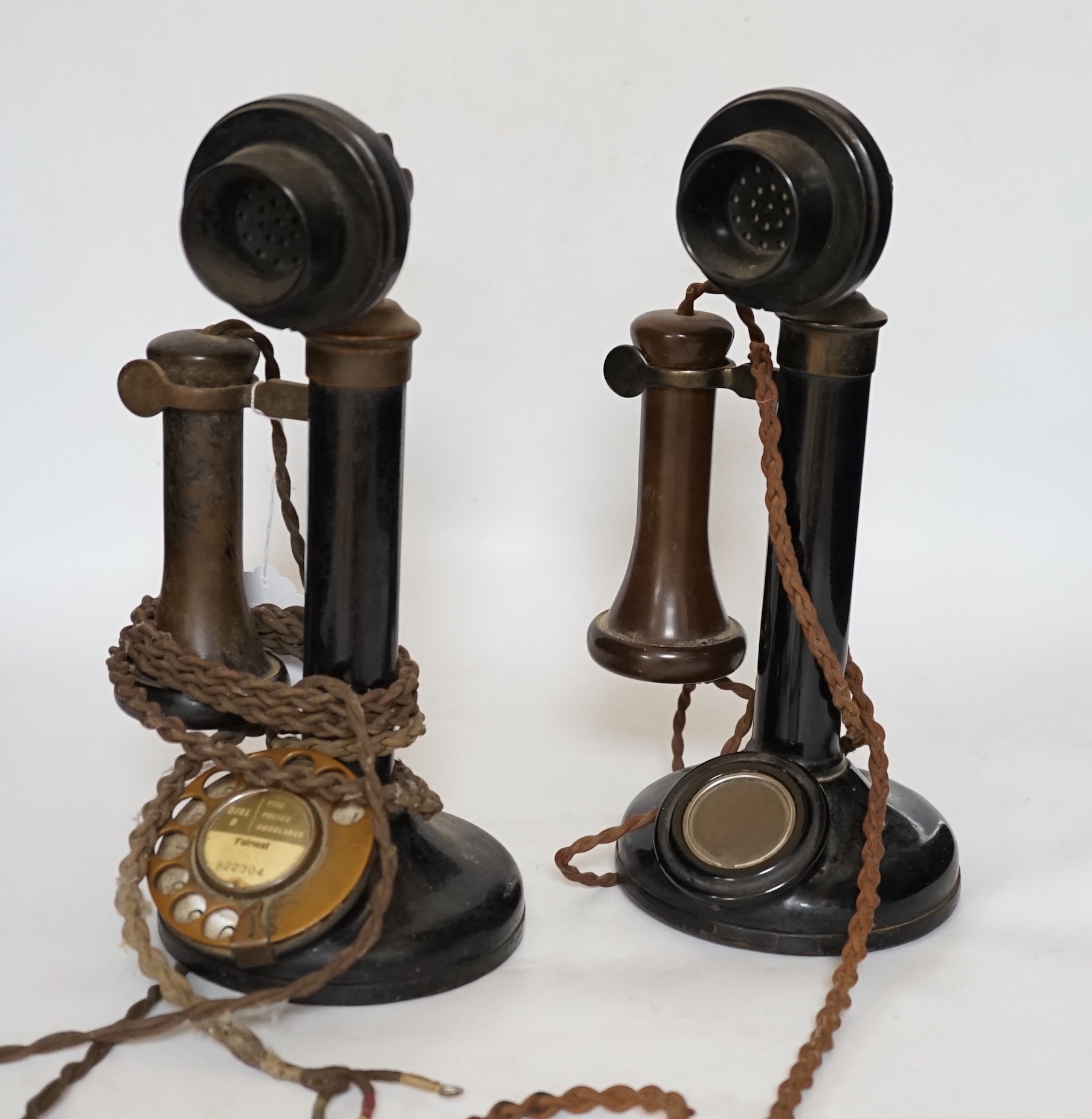 Two early black Bakelite pillar telephones, 31cm high